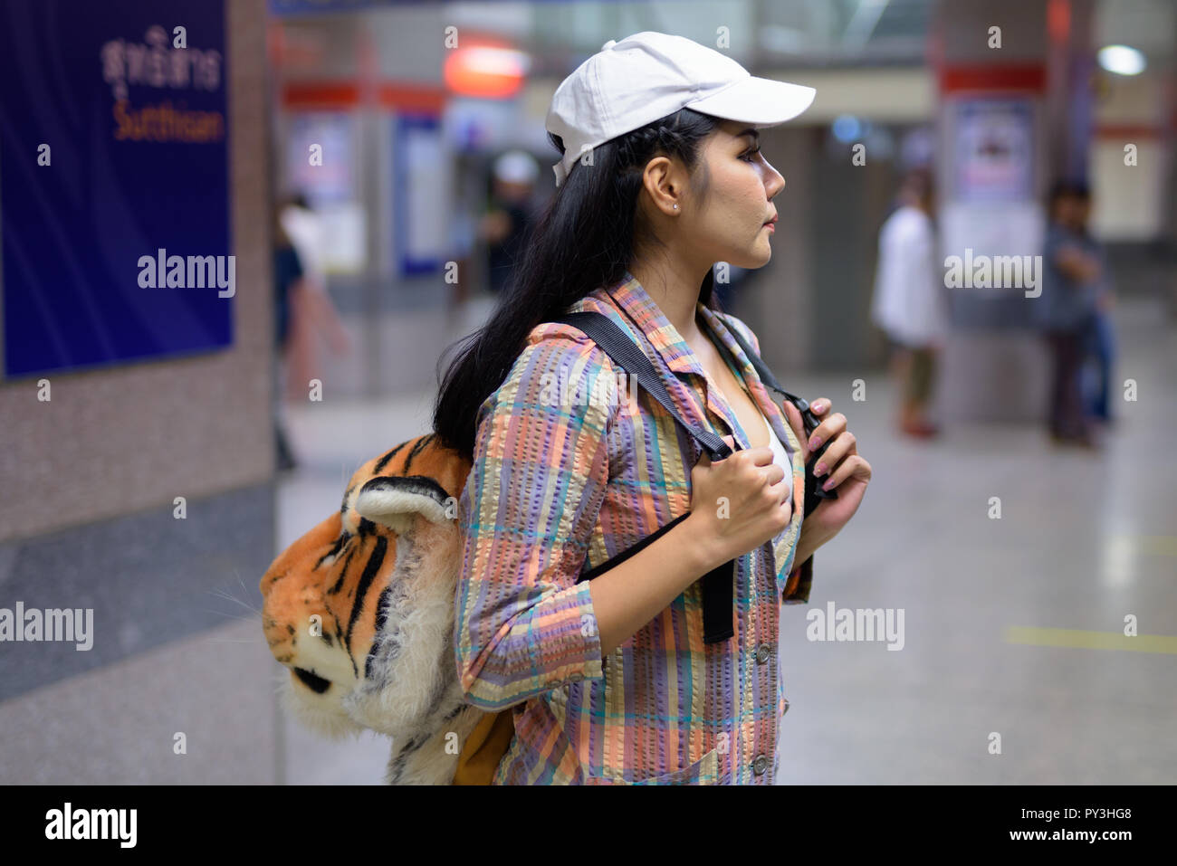 Vista di Profilo di donna asiatica in attesa del treno nella stazione della metropolitana Foto Stock