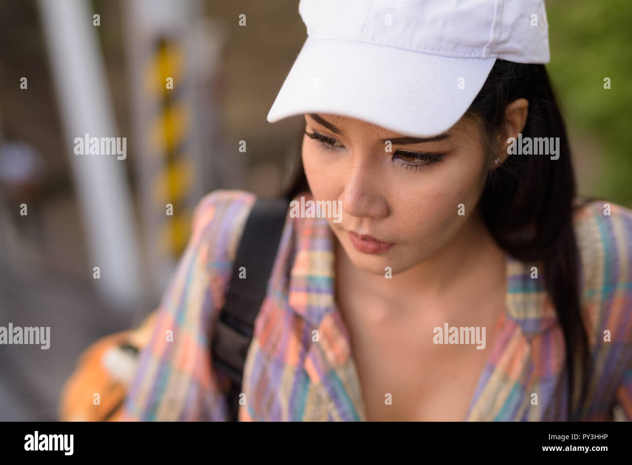 Donna asiatica in piedi in escalator mentre pensando Foto Stock