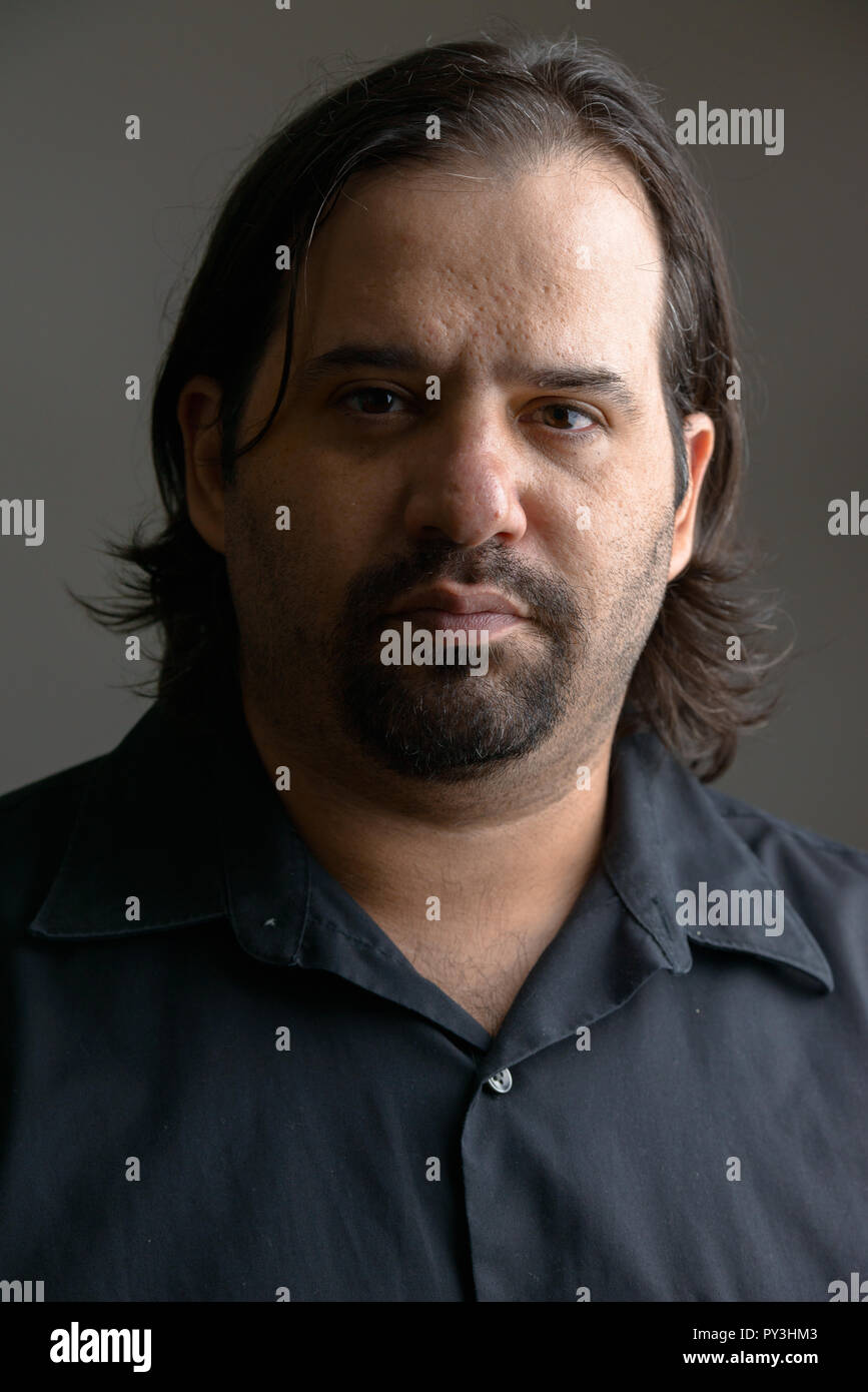La faccia di grasso uomo caucasico nel buio Foto Stock