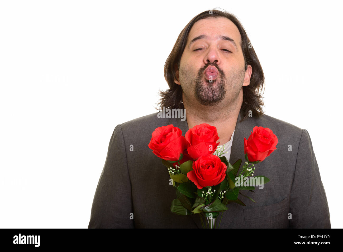 Grasso imprenditore caucasico raggrinzamenti labbra tenendo rose rosse Foto Stock