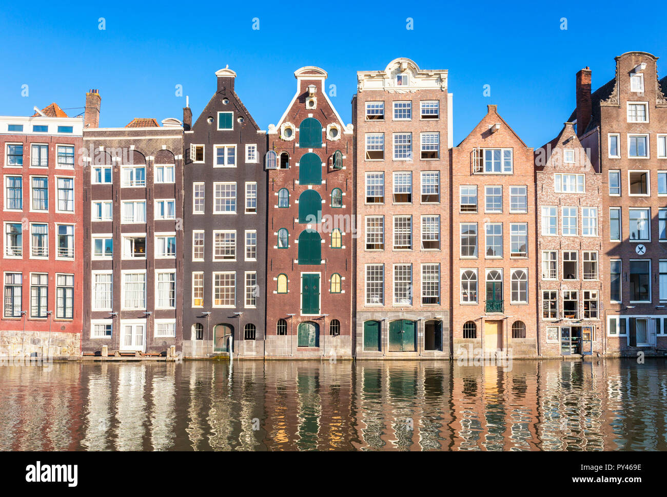 Case di Amsterdam su Damrak Una parzialmente riempito in canal dancing case con architettura olandese dal canal Amsterdam Olanda Paesi Bassi EU Europe Foto Stock