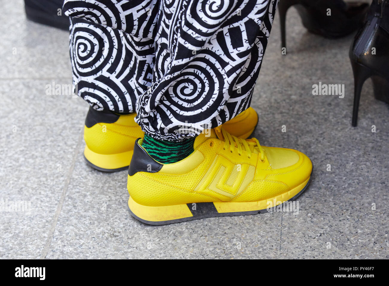 Milano, Italia - 23 settembre 2018: l'uomo con giallo sneakers, calze di verde e nero e pantaloni bianchi prima di Cristiano Burani Fashion show, Milano Fash Foto Stock