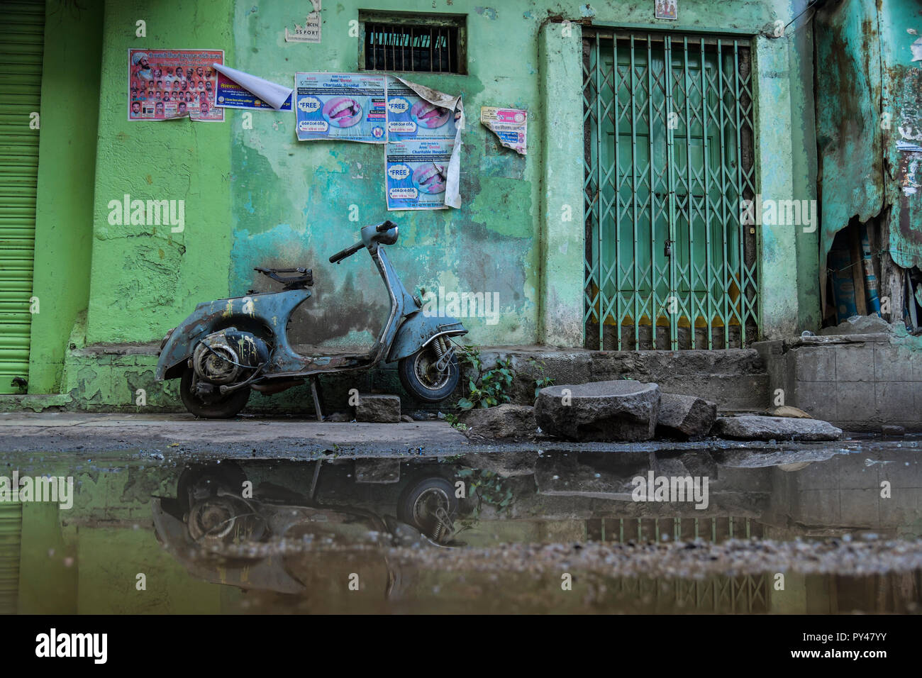 Scooter di antiquariato in acqua stagnante ha portato questa riflessione rendendo così bella composizione. Foto Stock