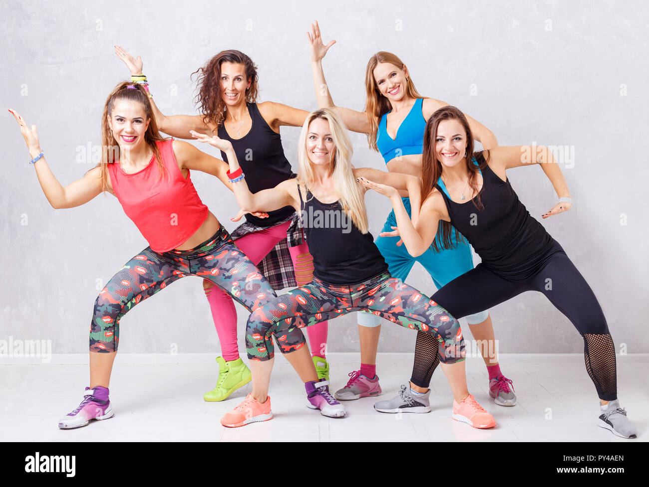 Gruppo di sorridenti ragazze fitness divertirsi insieme. Ginnastica aerobica fitness il concetto di gruppo sullo sfondo Foto Stock