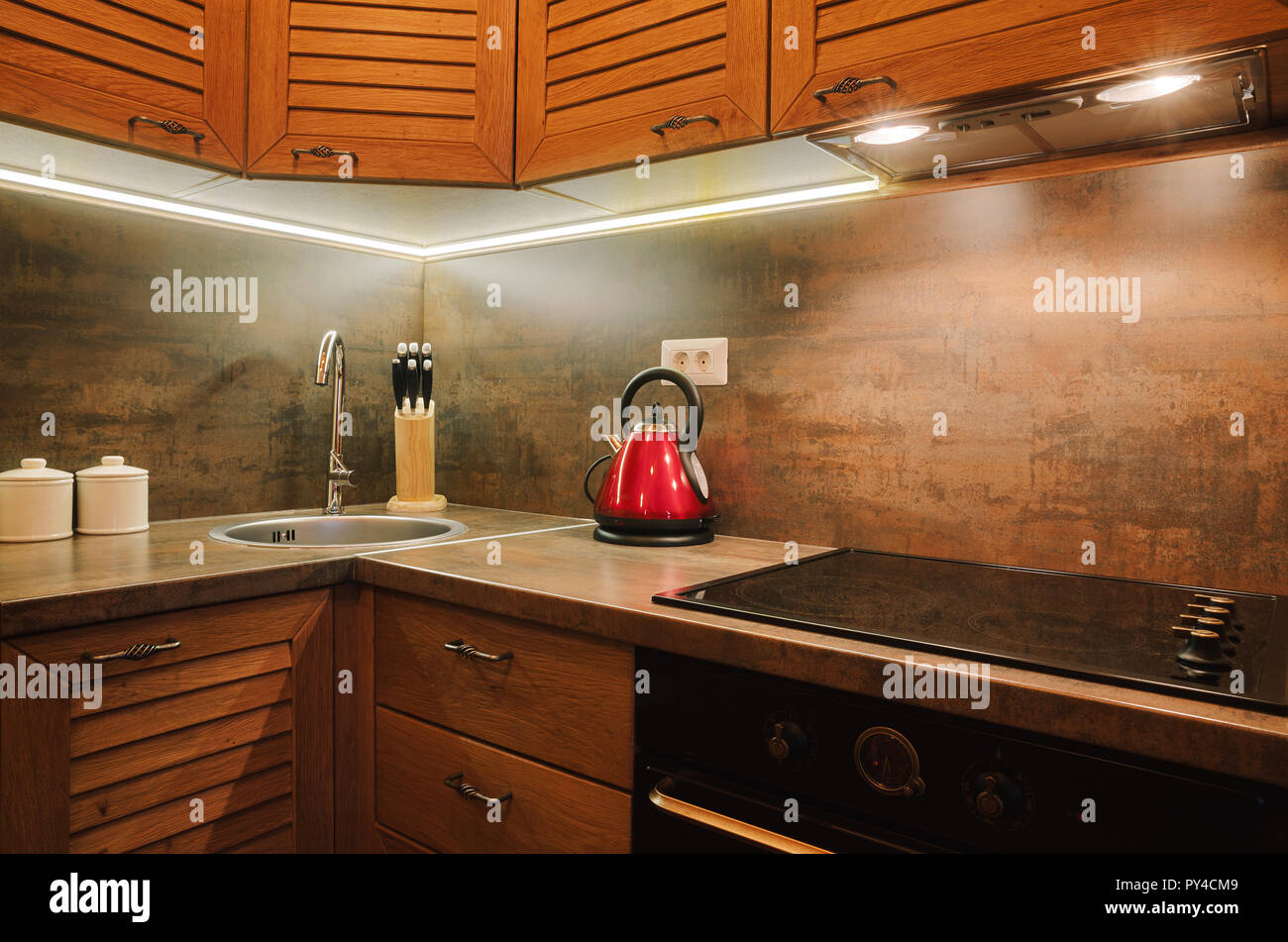 Interno di un piccolo appartamento, dettagli di cucina marrone con parti in legno. Foto Stock