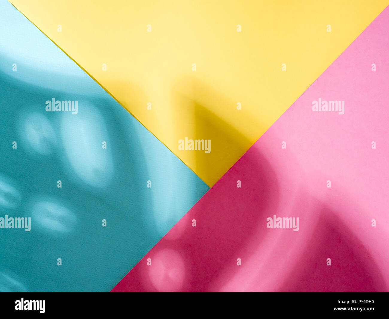 Foglia di monstera ombra sulla colorata di rosa blu sfondo giallo. Pianta tropicale monstera ombra. Layout creativi per la progettazione, la carta da parati. Copia spazio per il testo. Foto Stock