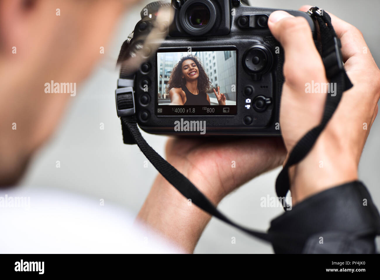 Digital single lens reflex in mani. Fotografo mani riprese da vicino. L'uomo fotografo rende le foto per la fotografia stock. Maschio di tenere le mani Foto Stock