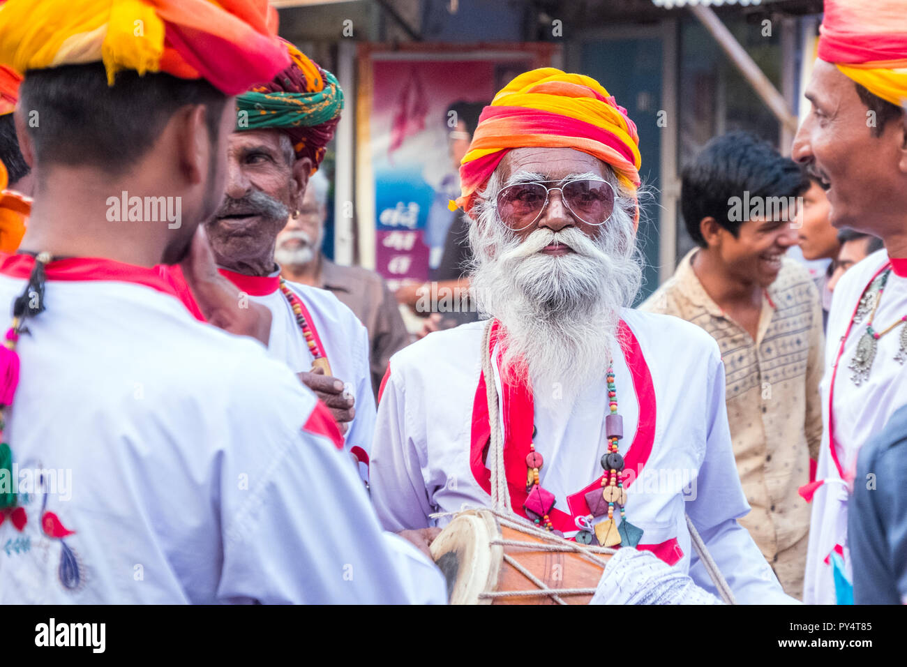 Uomo anziano con la barba e il tamburo in una sfilata in Rajasthan in India Foto Stock