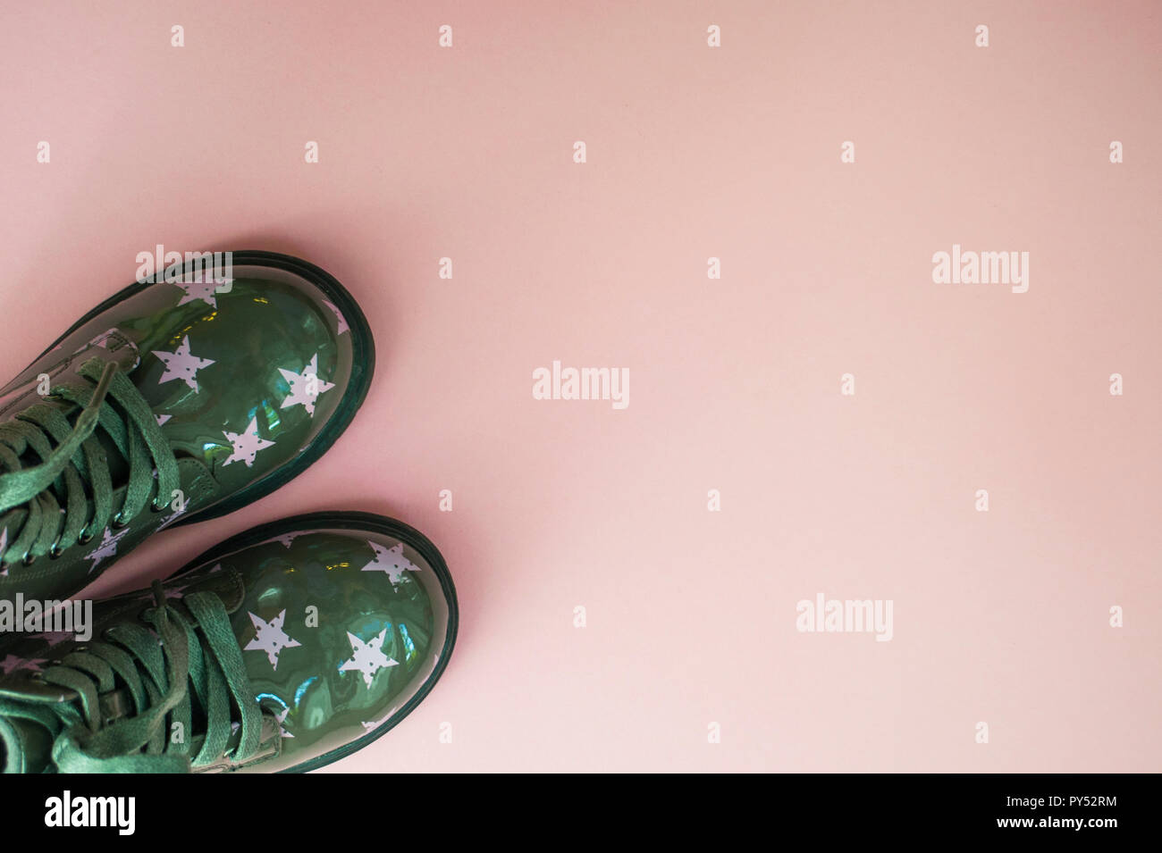 Carino per bambini colore verde scarpe con star stampa su sfondo rosa con copyspace. Foto Stock