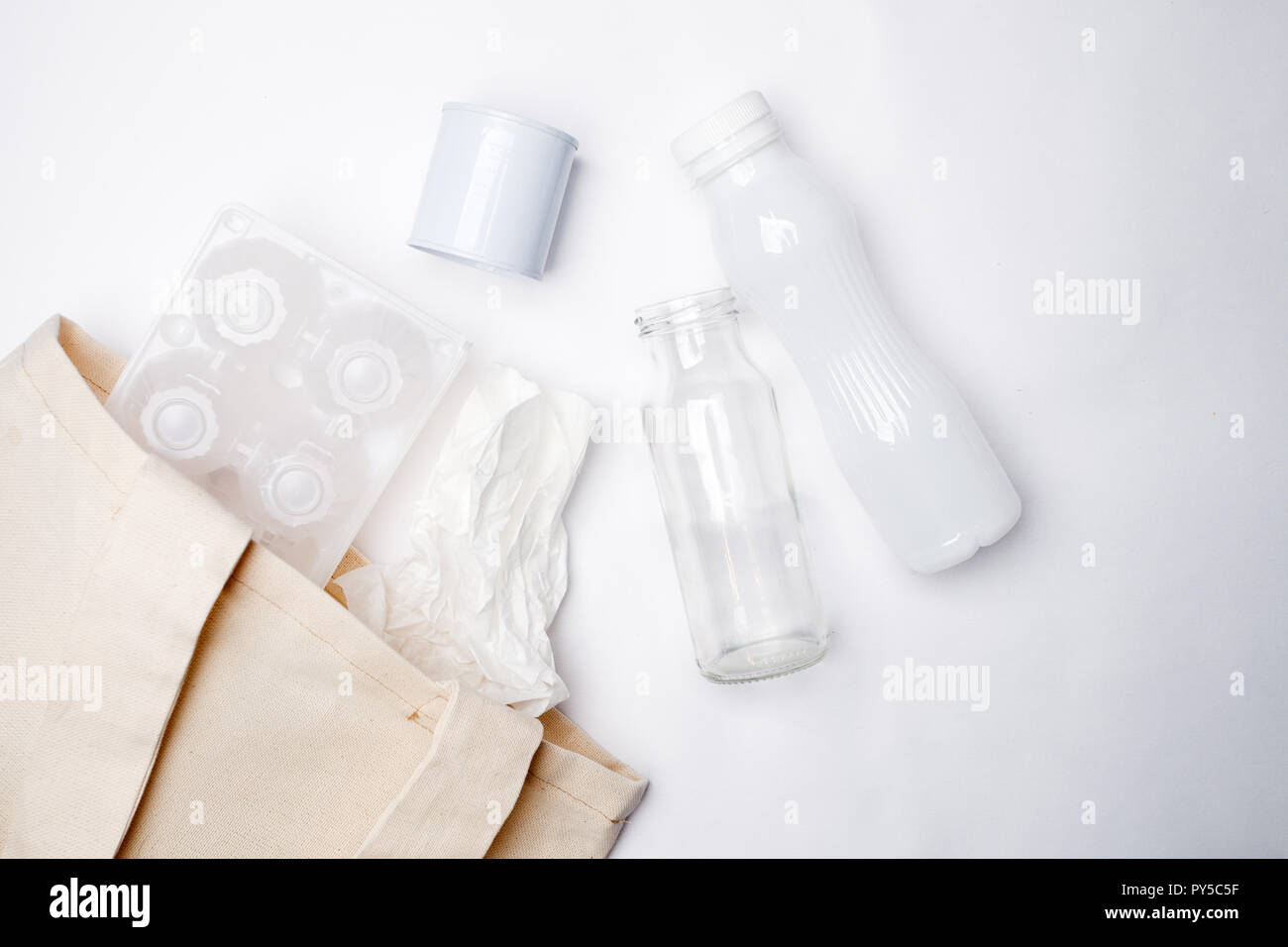 Separare la garbage collection: sacchetto di tessuto e di imballaggio delle uova, carta, bottiglia di vetro e alluminio può. Concetto di eco. Lay piatto Foto Stock