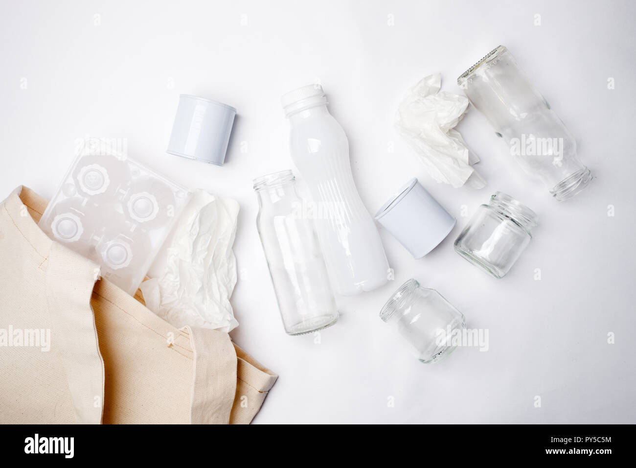 Separare la garbage collection: sacchetto di tessuto e di imballaggio delle uova, carta, bottiglia di vetro e alluminio può. Concetto di eco. Lay piatto Foto Stock