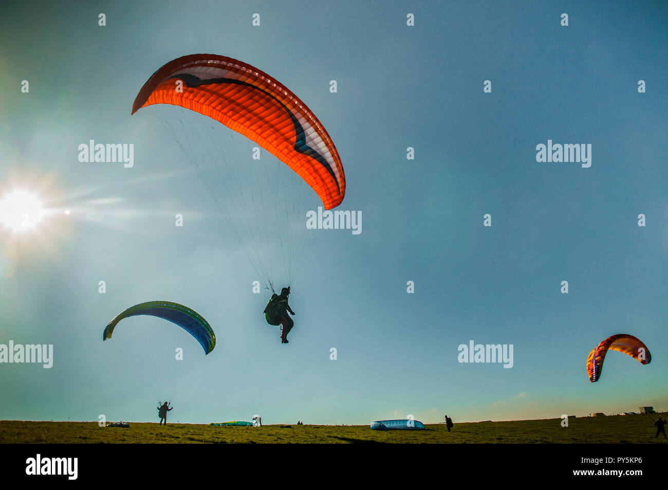 Firle, Lewes, East Sussex, Regno Unito. 25 ottobre 2018..un vento freddo dal Nord porta piloti di parapendio a Firle Beacon nella bella South Downs. Foto Stock