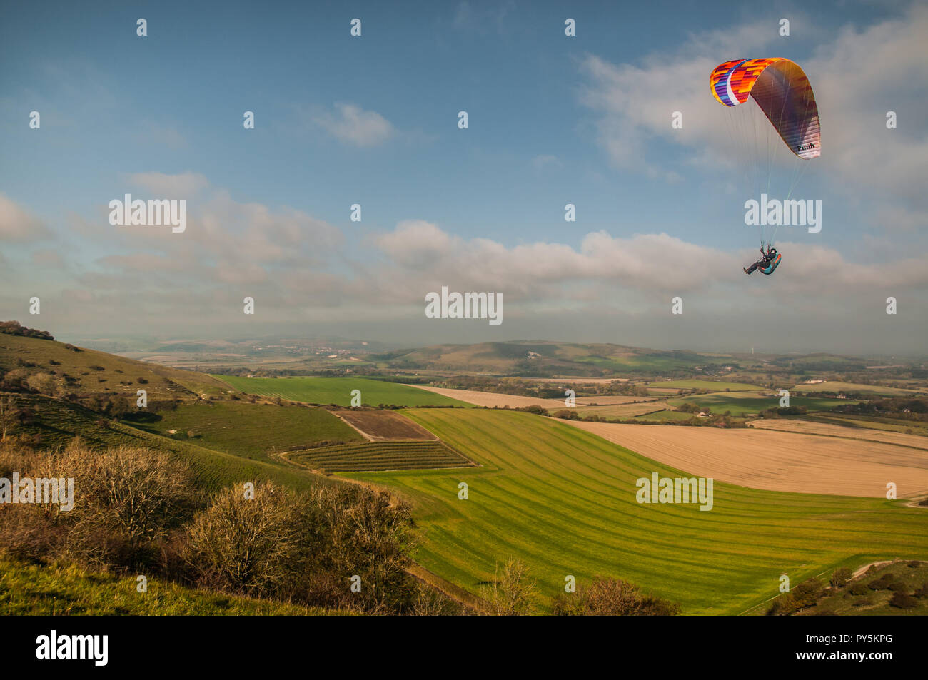 Firle, Lewes, East Sussex, Regno Unito. 25 ottobre 2018..un vento freddo dal Nord porta piloti di parapendio a Firle Beacon nella bella South Downs. Foto Stock