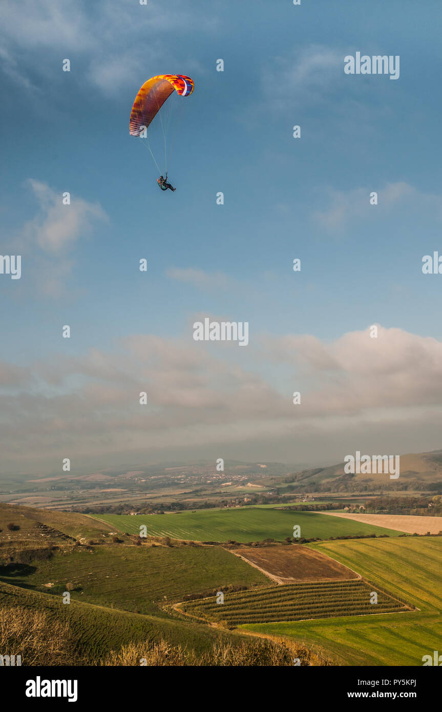 Firle, Lewes, East Sussex, Regno Unito. 25 ottobre 2018..un vento freddo dal Nord porta piloti di parapendio a Firle Beacon nella bella South Downs. Foto Stock