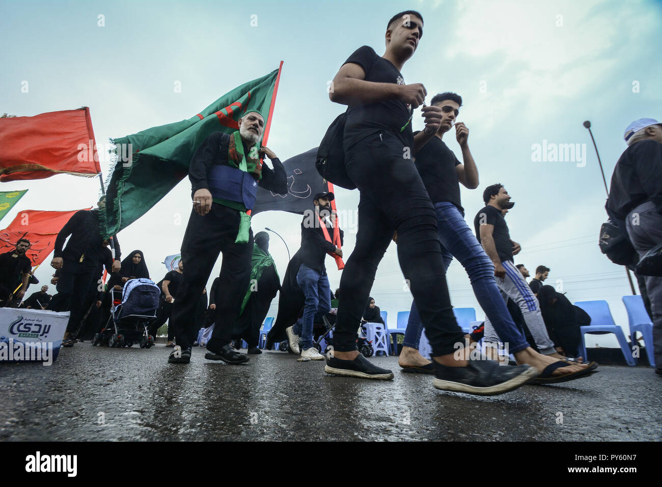 Baghdad in Iraq. 25 ott 2018. Sciita irachena pellegrini fanno la loro strada per la tomba di Imam Hussain durante un giorno di pioggia per eseguire la cerimonia religiosa il quarantesimo giorno dopo la santa sciita giorno di Ashura che commemora la morte di imam Hussein nella battaglia di Karbala. Credito: Ameer Al Mohammedaw/dpa/Alamy Live News Foto Stock