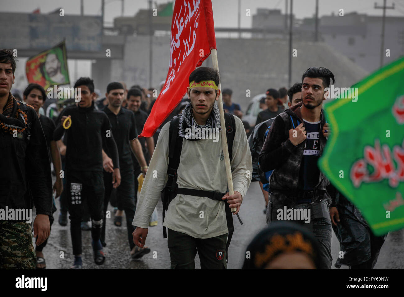 Baghdad in Iraq. 25 ott 2018. Sciita irachena pellegrini fanno la loro strada per la tomba di Imam Hussain durante un giorno di pioggia per eseguire la cerimonia religiosa il quarantesimo giorno dopo la santa sciita giorno di Ashura che commemora la morte di imam Hussein nella battaglia di Karbala. Credito: Ameer Al Mohammedaw/dpa/Alamy Live News Foto Stock