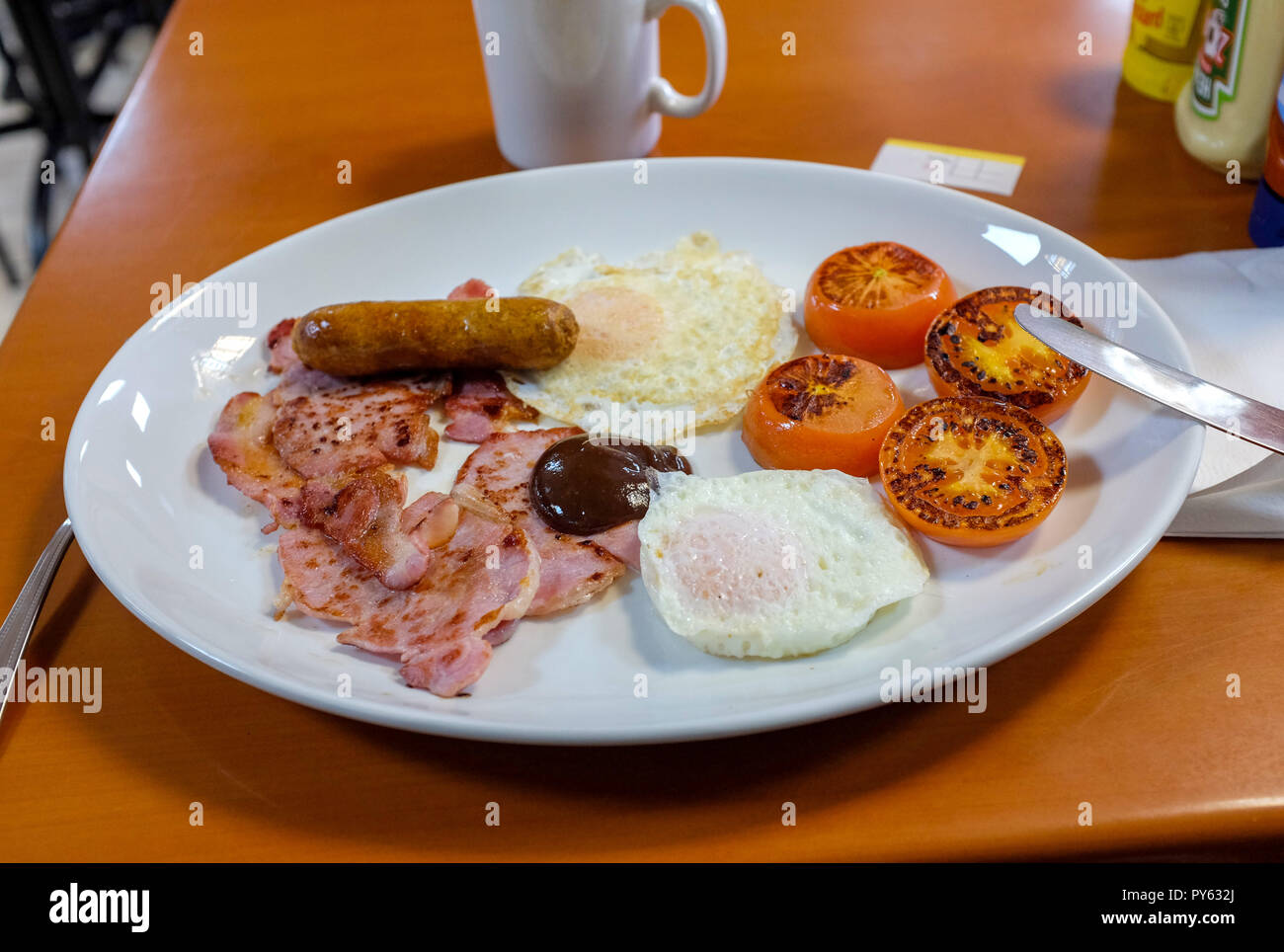 Tipica colazione inglese tradizionale di salsiccia pancetta uova fritte e pomodori a Fat Boy Cafe di New Malden Kingston Foto Stock