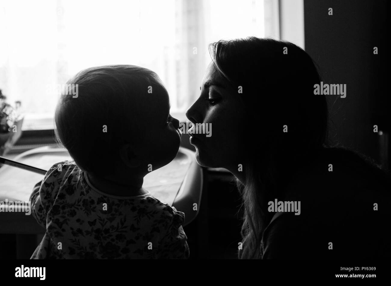 Giovani due anni toddler baby ragazza baciare la madre Foto Stock