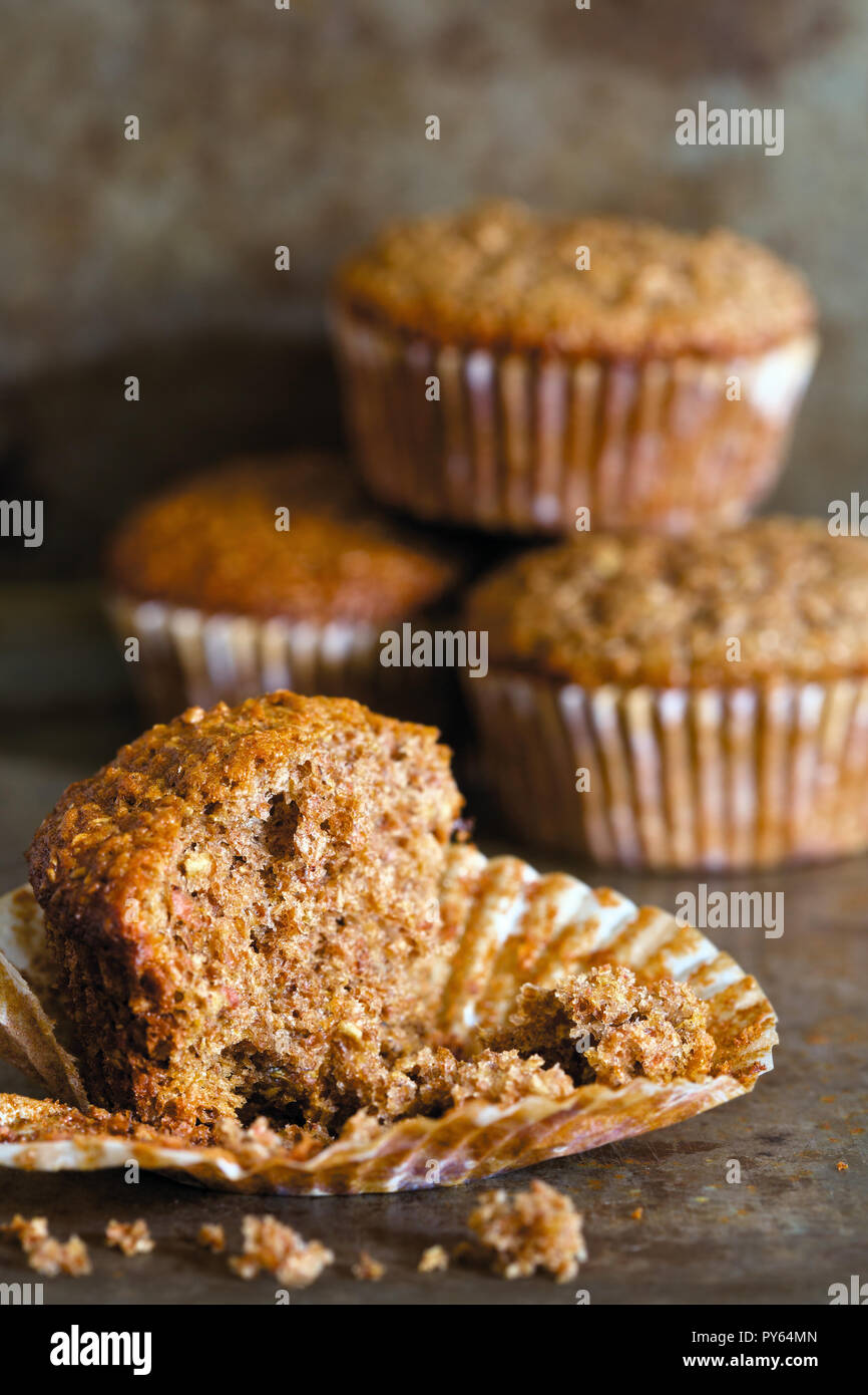 Close up di un muffin di crusca con le briciole e muffin in background. Foto Stock