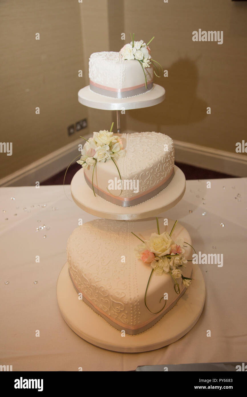 Torta di nozze, bianco glassati con fiori la decorazione è pronto per essere tagliato su un giorno di nozze Foto Stock