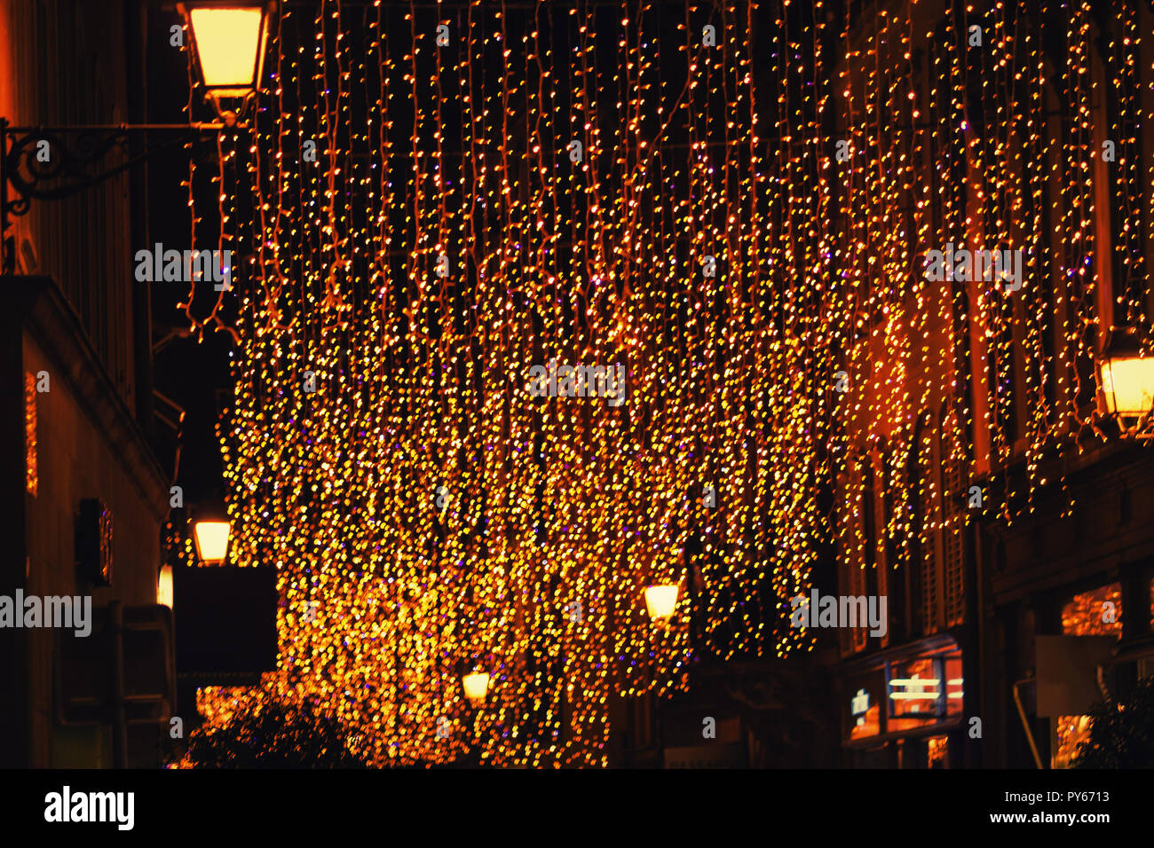 Sfocate luci colorate sulla strada della citta'. Decorazioni di Natale vacanze sfondo bokeh di fondo. Foto Stock