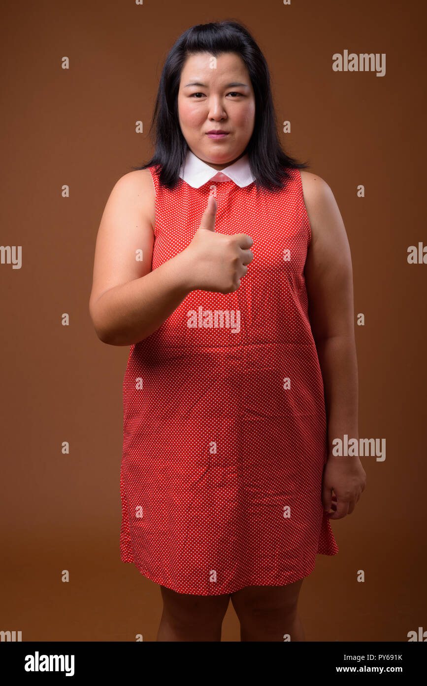 Bellissimo il sovrappeso donna asiatica dando pollice in alto Foto Stock