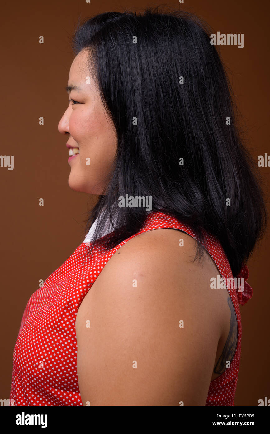 Vista di profilo di bella sovrappeso donna asiatica volto sorridente Foto Stock