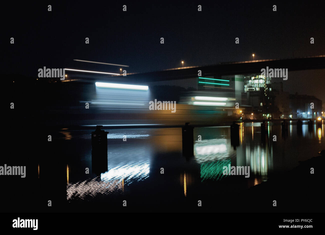 I percorsi della luce a sinistra da una nave sul canale di notte che si sta dirigendo verso il ponte di Olympia Kiel-Holtenau. Foto Stock