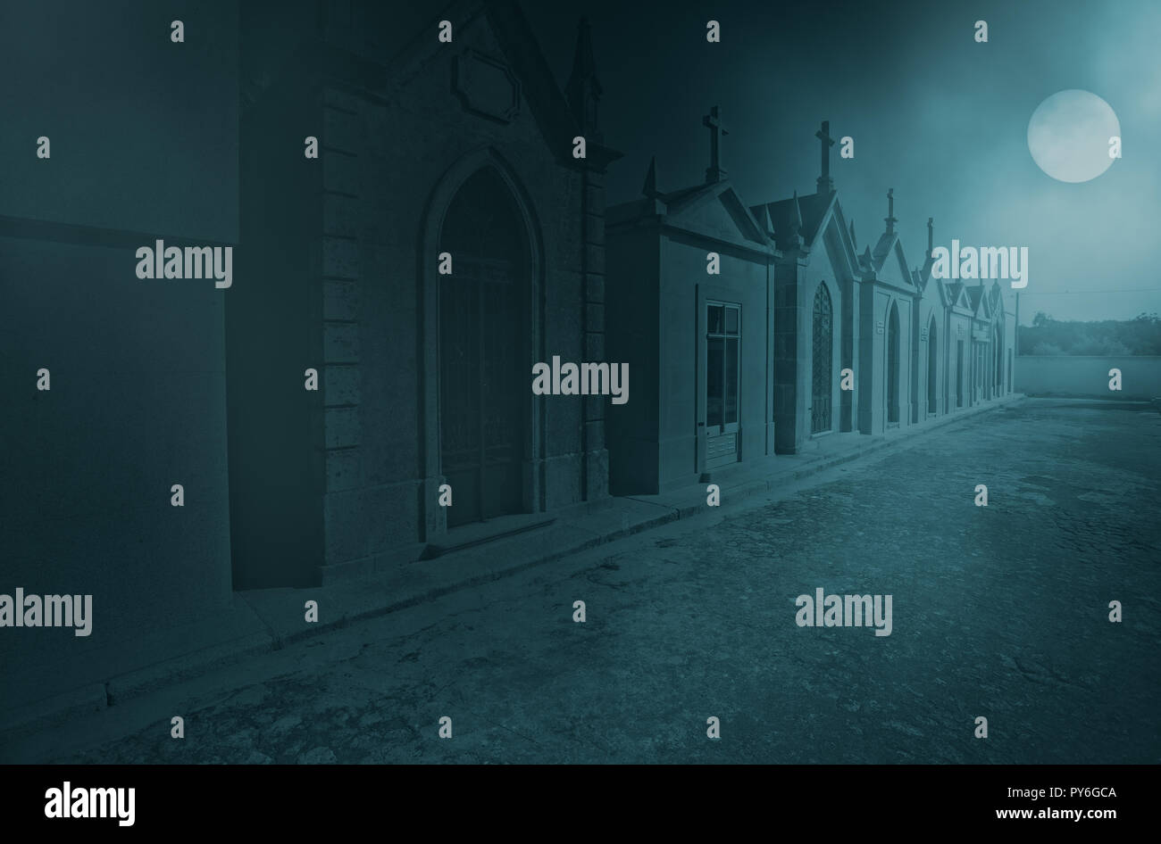 Vecchio Cimitero europeo in una nebbiosa notte di luna piena che può essere usato come un buon background di halloween Foto Stock