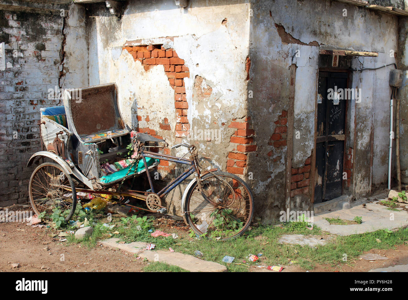 Il vecchio e abbandonato risciò bicicletta e di fronte a un cancello in Varanasi. Preso in India, Agosto 2018. Foto Stock