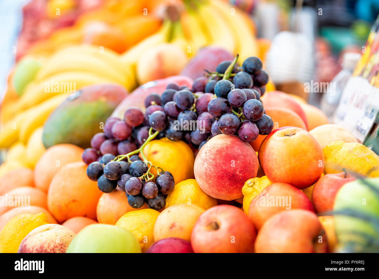 Primo piano della freschi maturi, il viola, l'arancione e giallo le pesche noci e le nettarine, pesche, arance, manghi, uva nella strada del mercato display in Italia durante il periodo estivo Foto Stock