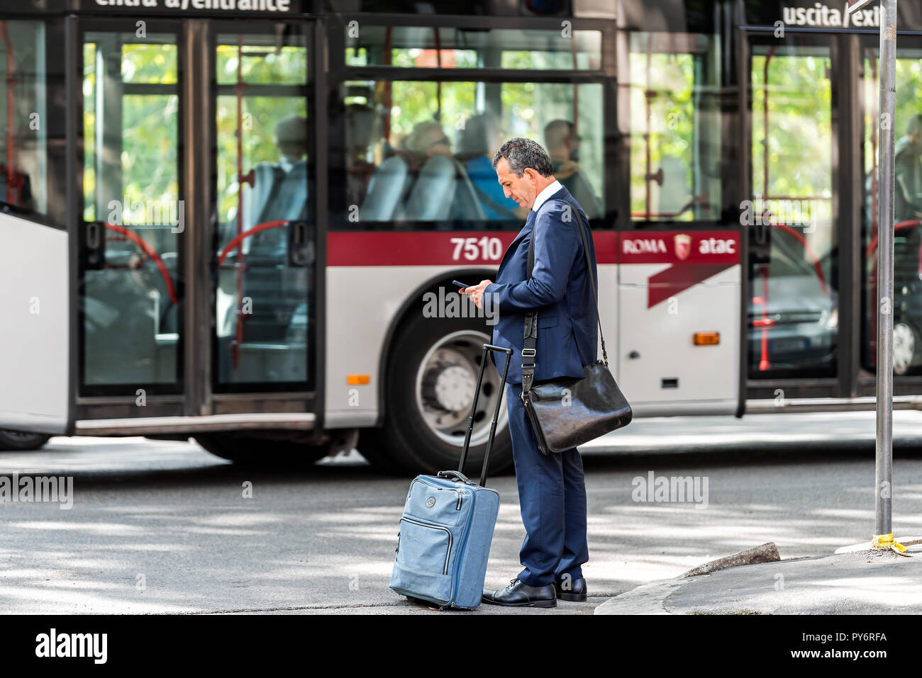 Roma, Italia - 4 Settembre 2018: Uno locale italiano uomo in città il lavoro di strada, imprenditore in attesa fuori per bus in blu ufficio business suit, Foto Stock