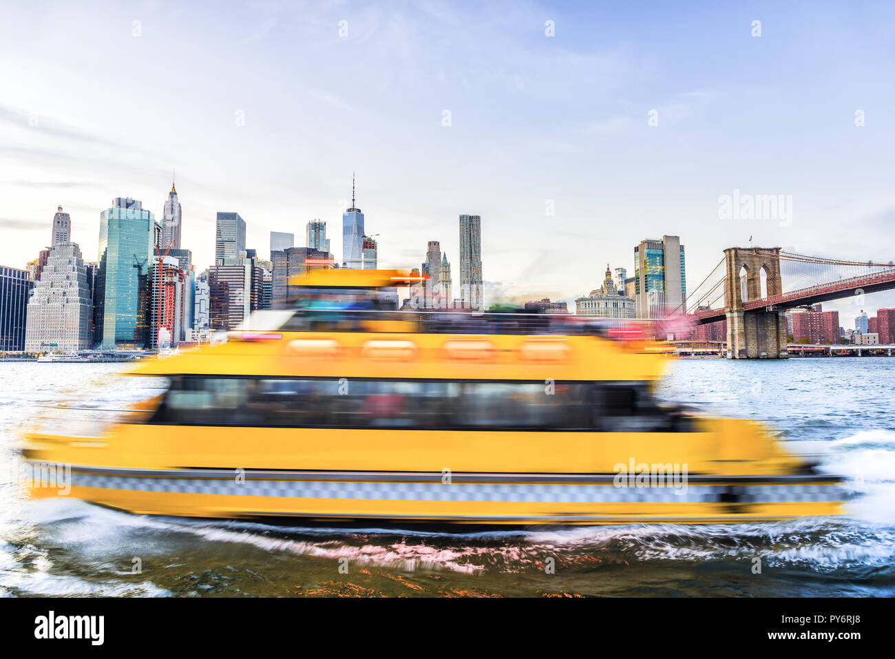 Vista Outdooors su NYC New York City Ponte di Brooklyn Park da East River, cityscape skyline al tramonto, grattacieli, edifici, onde, giallo tour in barca, Foto Stock