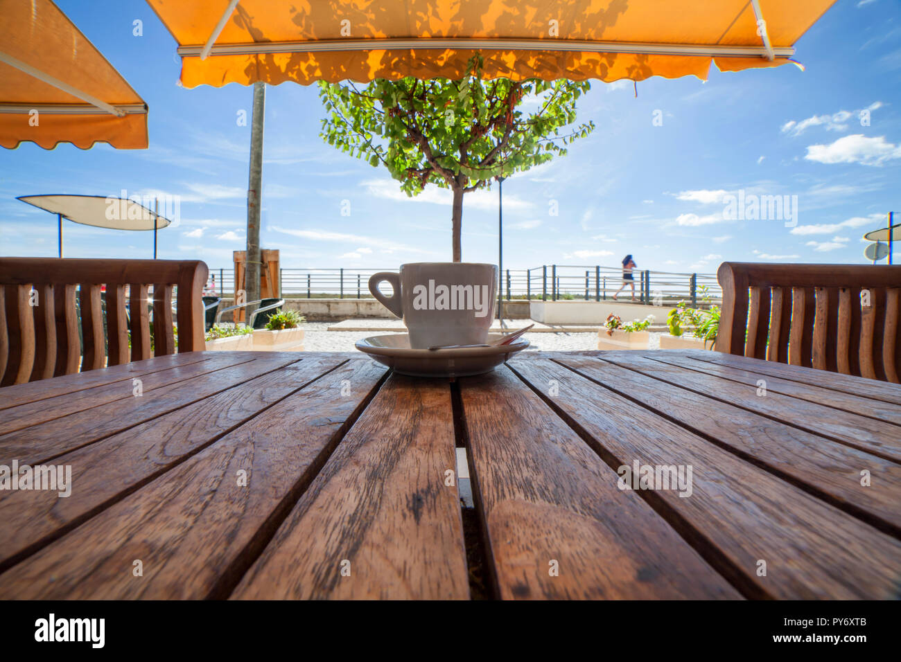 Il portoghese tazza di caffè o di bica su un tavolo di legno. In un momento di relax a terrazza di Cabanas de Tavira, Algarve, PORTOGALLO Foto Stock