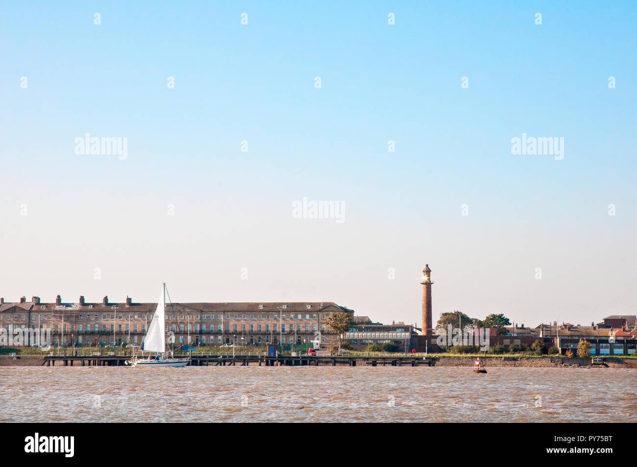 Yatch sail;ing passato il superiore (Pharos) faro fleetwood . Faro è situato nella stessa città. È Sunlighgt Rreflecting da finestre superiori . Foto Stock