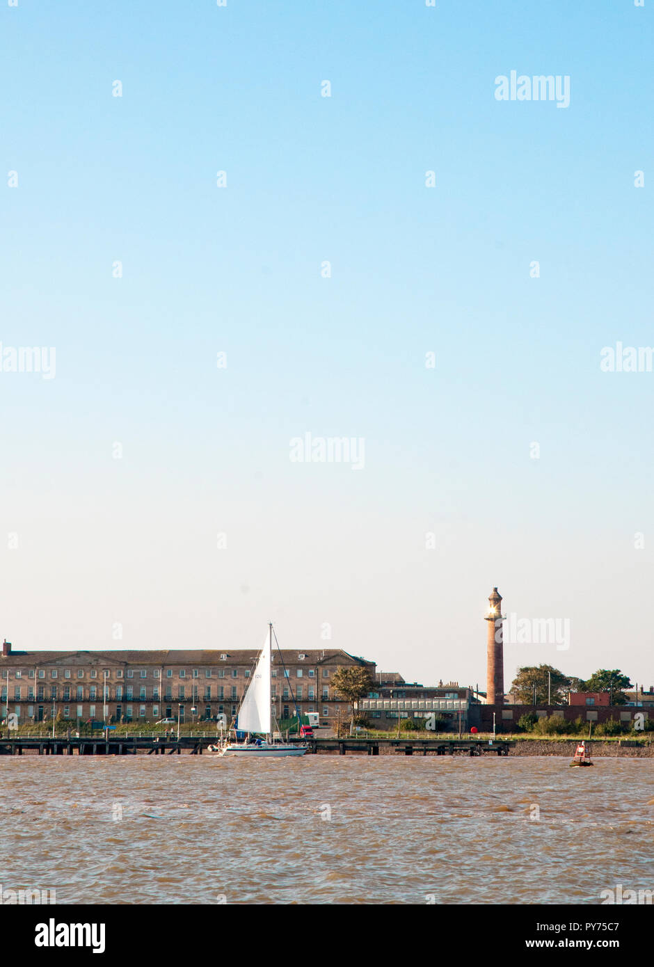 Yatch sail;ing passato il superiore (Pharos) faro fleetwood . Faro è situato nella stessa città. È Sunlighgt Rreflecting da finestre superiori . Foto Stock