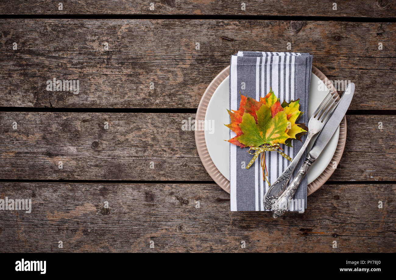 Autunno messa in tavola con foglie colorate Foto Stock