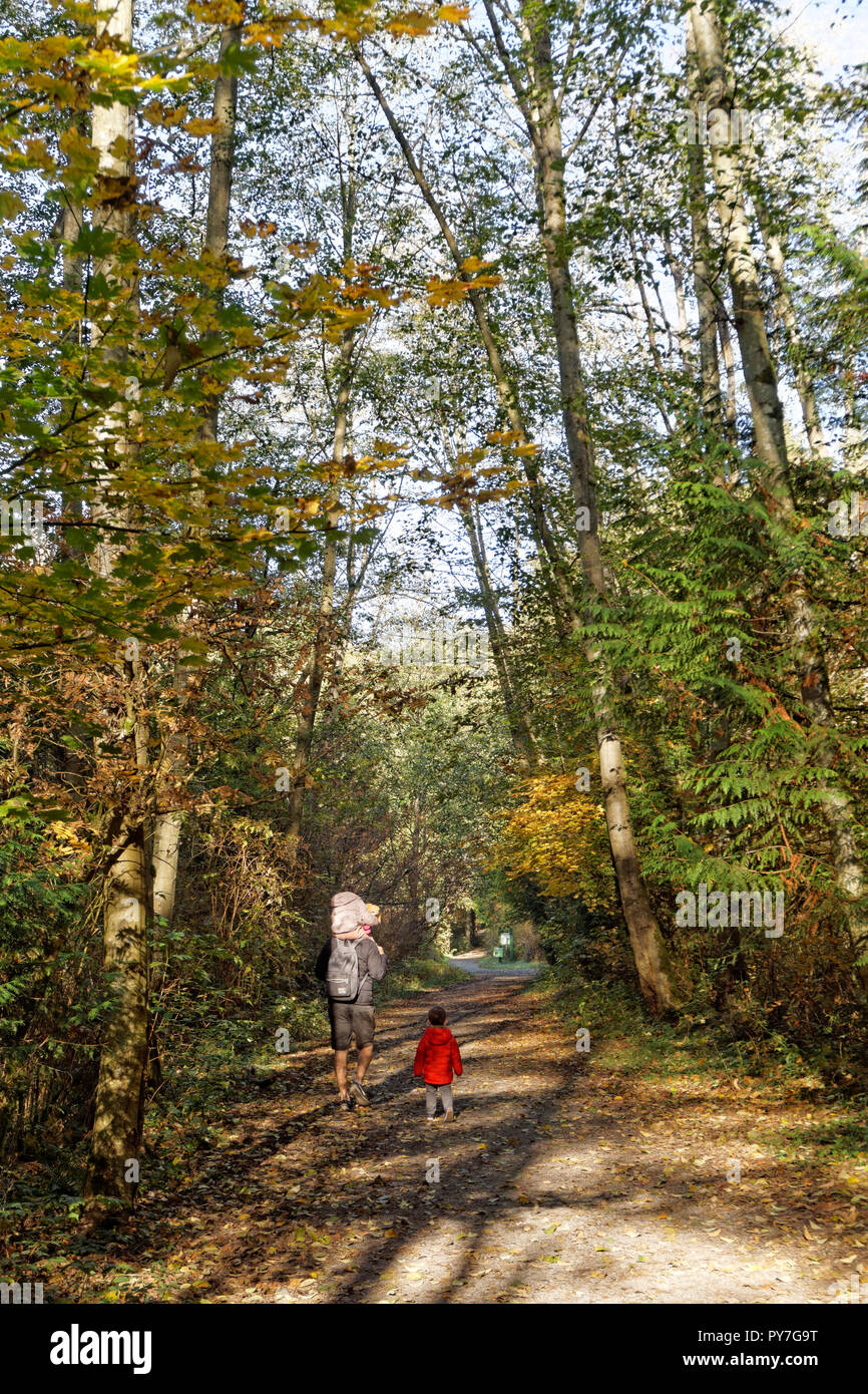 Padre e figli piccoli a piedi lungo un sentiero in spirito pacifico parco regionale e preservare la natura, Vancouver, BC, Canada Foto Stock