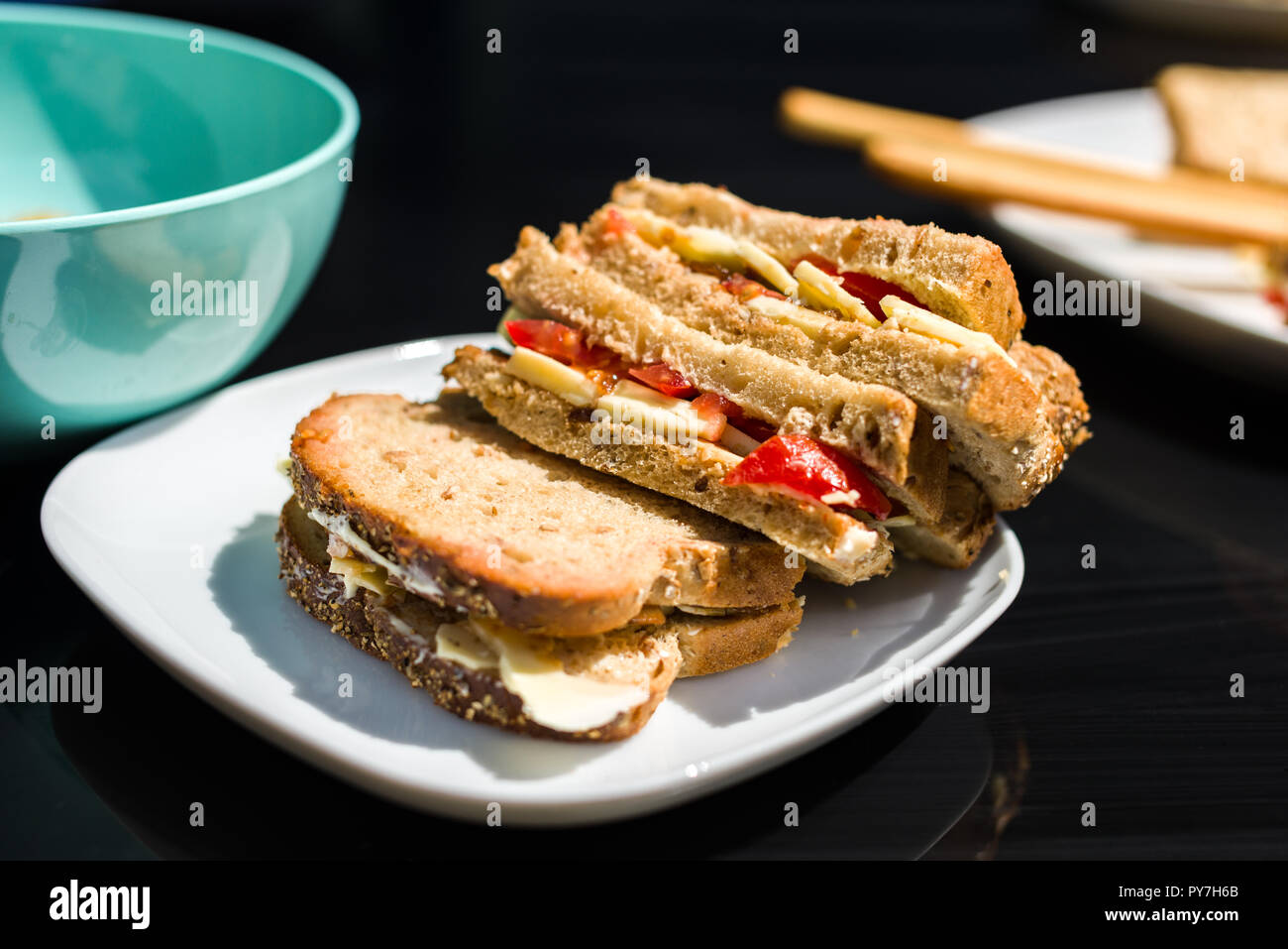Un granaio integrale formaggio e sandwich di pomodoro su una piastra bianca all'aperto in una giornata di sole, REGNO UNITO Foto Stock