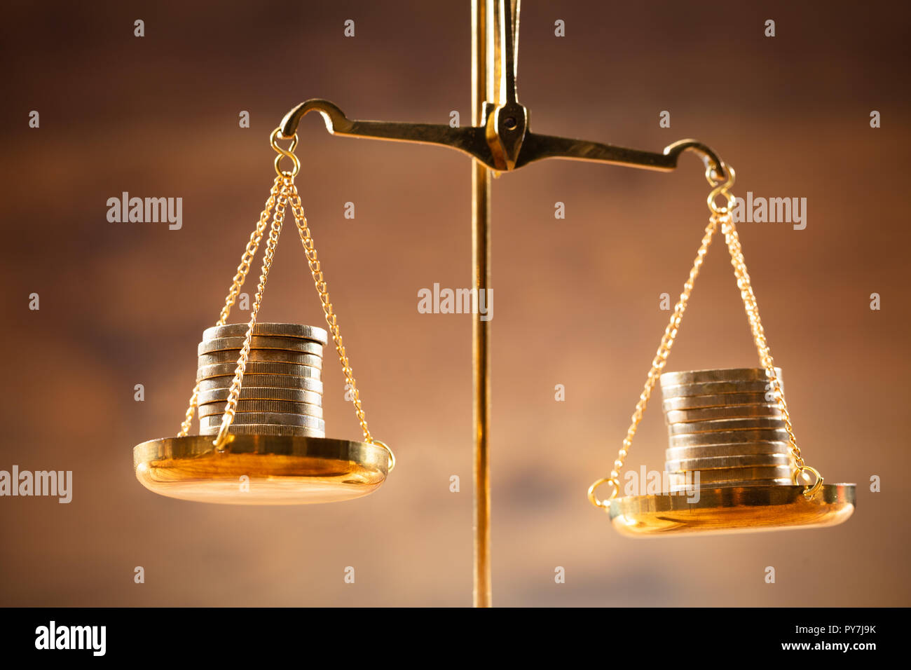 Close-up di Golden monete impilate su scala di giustizia Foto Stock