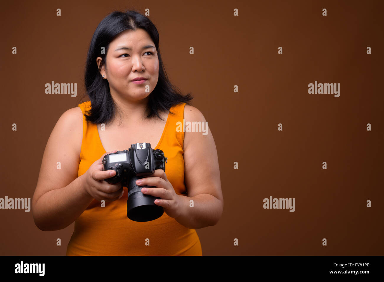 Bellissimo il sovrappeso donna asiatica fotografo pensando e progettando Foto Stock