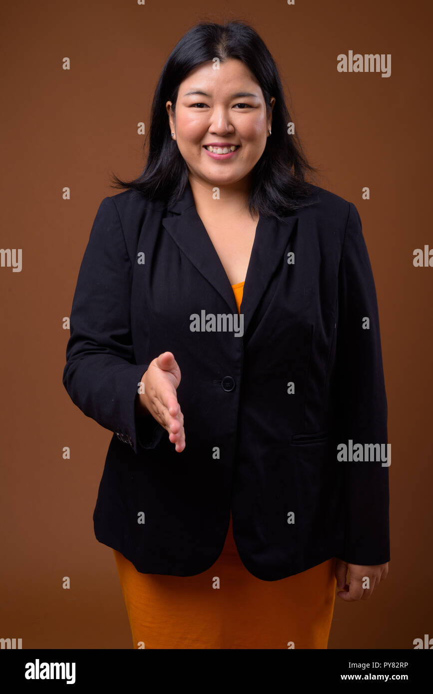 Bellissimo il sovrappeso Asian imprenditrice offrendo handshake e il messaggio di saluto Foto Stock