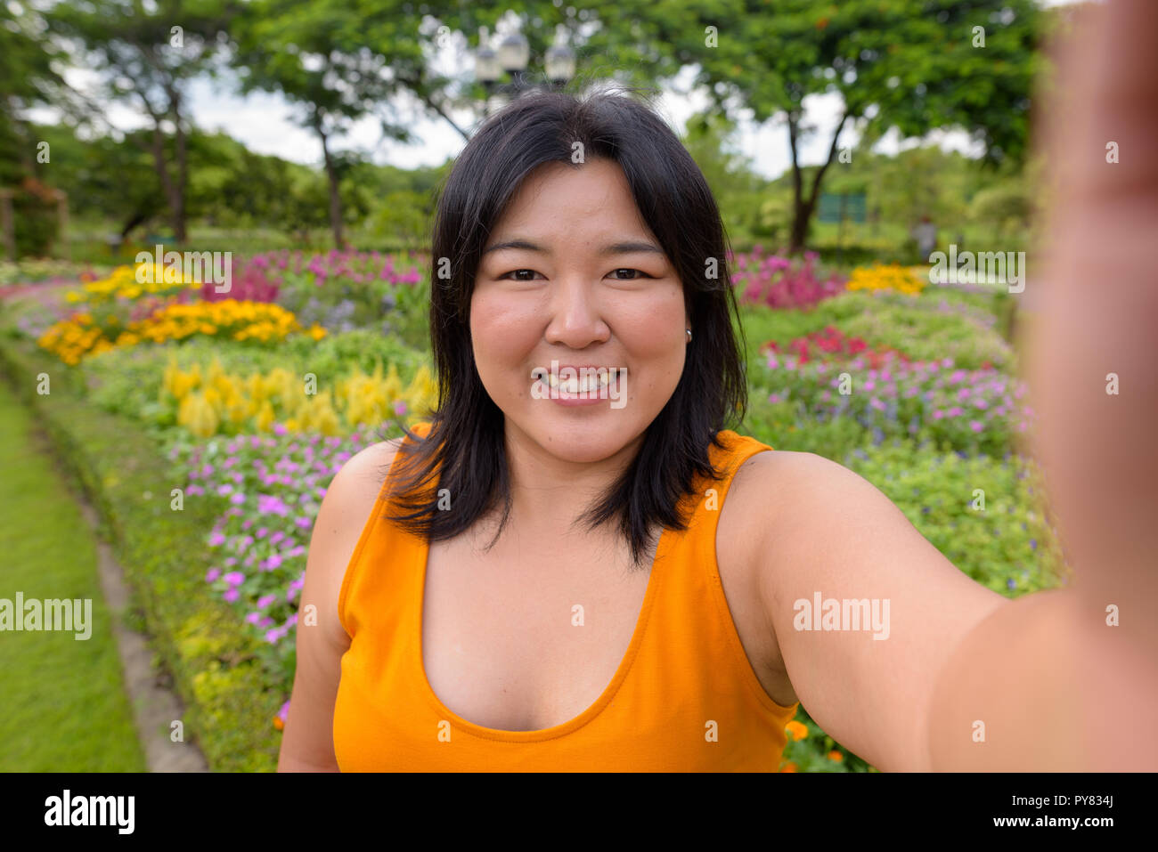 Personale punto di vista di bella donna sovrappeso tenendo selfie in posizione di parcheggio Foto Stock
