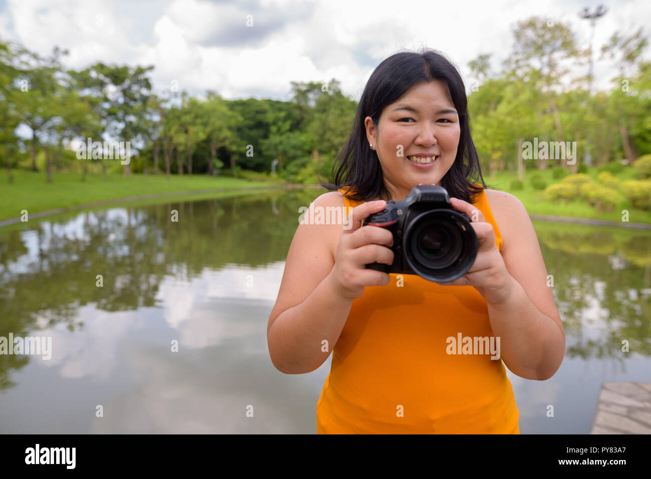 Donna asiatica fotografo in park pronto a scattare la foto Foto Stock