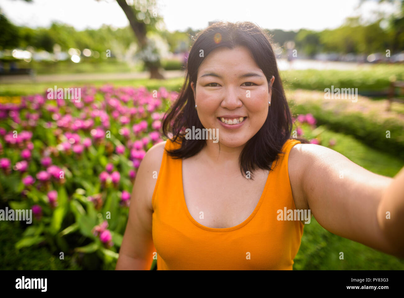 Personale punto di vista di bella donna sovrappeso tenendo selfie in posizione di parcheggio Foto Stock