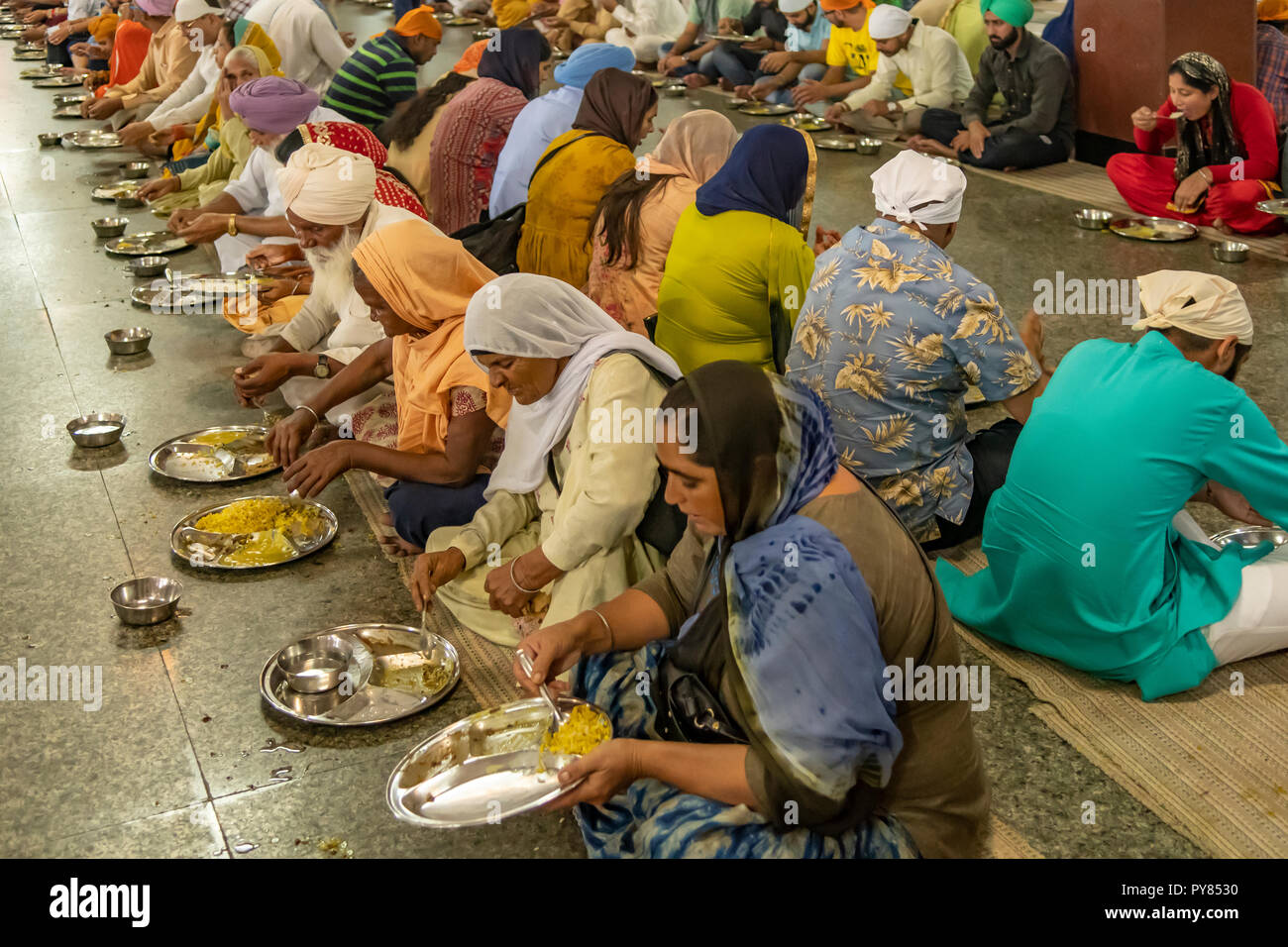 Mangiare alla Langar Hall La cucina della comunità,. Amritsar Punjab, India Foto Stock