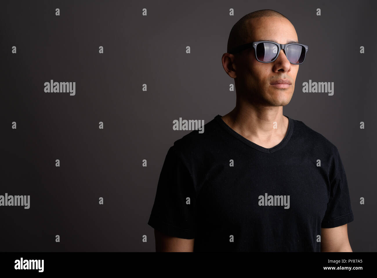 Bel uomo calvo indossando la maglia nera e occhiali da sole Foto stock -  Alamy
