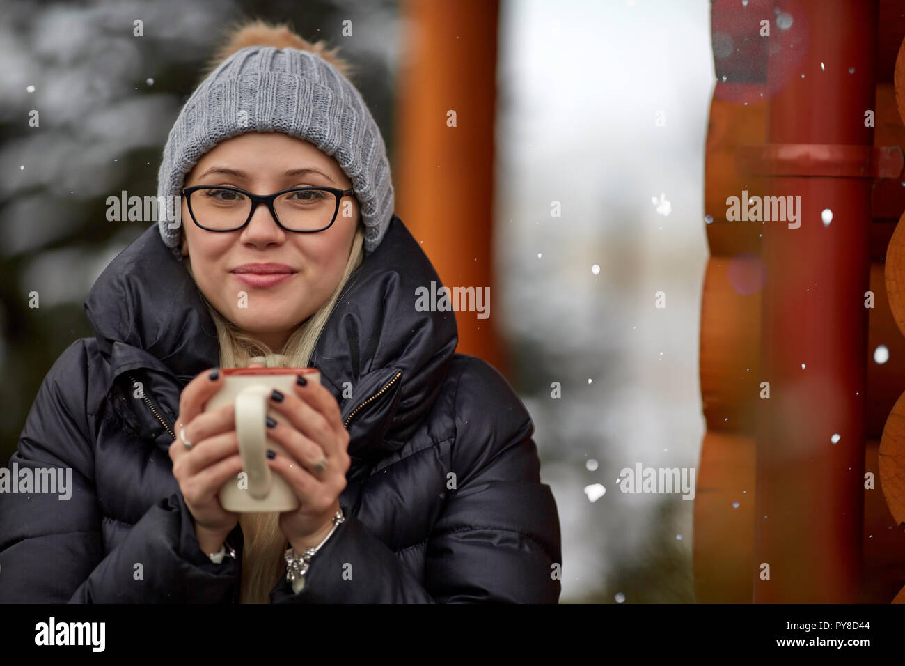 Donna con bevanda calda sul giorno di inverno Foto Stock
