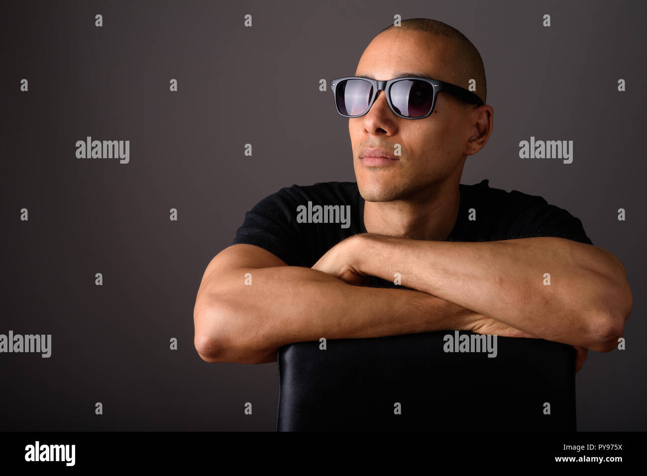 Ritratto di bello uomo calvo seduti su una sedia e indossando occhiali da  sole Foto stock - Alamy