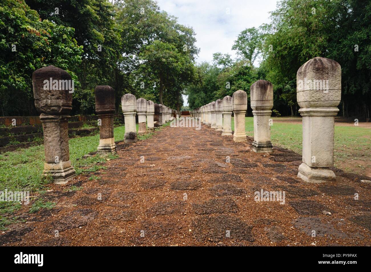 Laterite tratto lastricato in pietra con pali in pietra alle porte dell' antico tempio Khmer Prasat Sdok Kok Thom in Sa Kaeo provincia della Thailandia Foto Stock